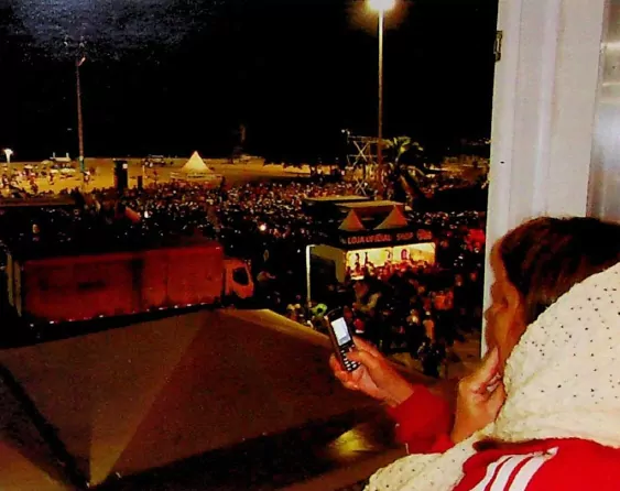 Foto da dona Maria Alice fazendo o registro da passagem do Papa