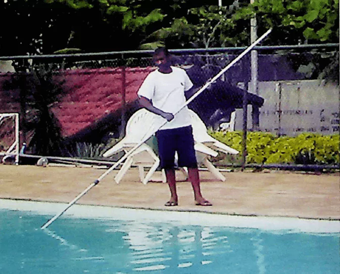 Profissional realizando a limpeza da piscina