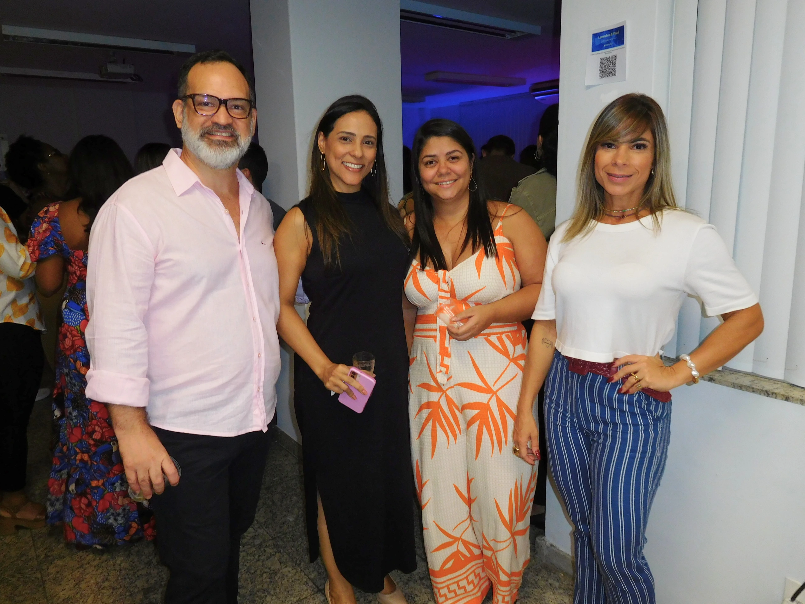 diversas funcionárias da Lowndes sorrindo para a câmera, com a logo no fundo